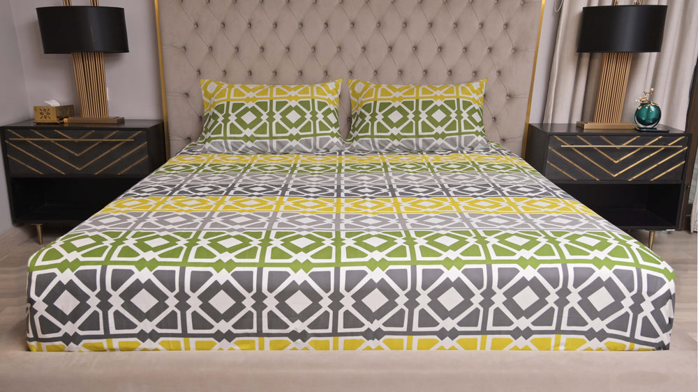 Bed with patterned bedding in a bedroom setting with nightstands and lamps.