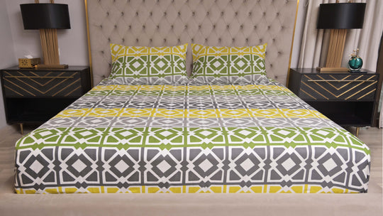 Bed with patterned bedding in a bedroom setting with nightstands and lamps.