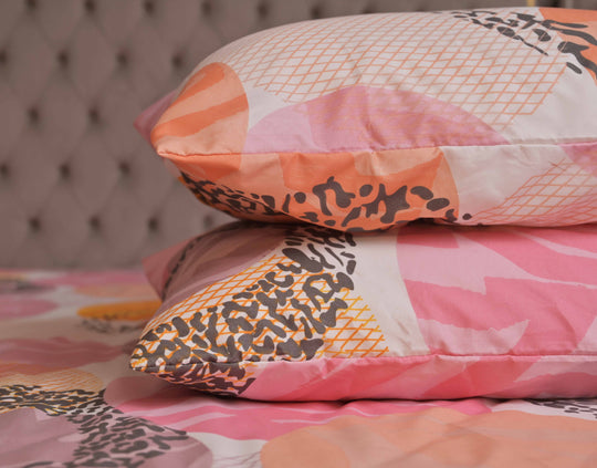 Stack of patterned pillows on a bed with a blurred background