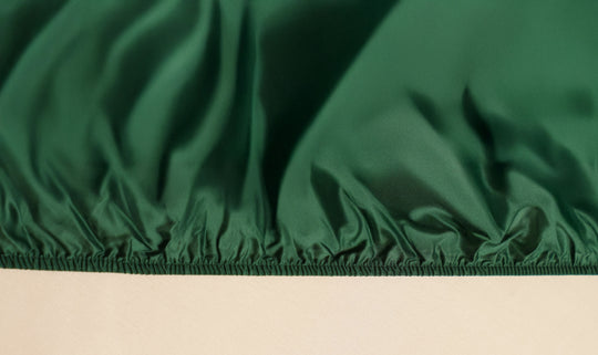 Close-up of green fabric with a beige background