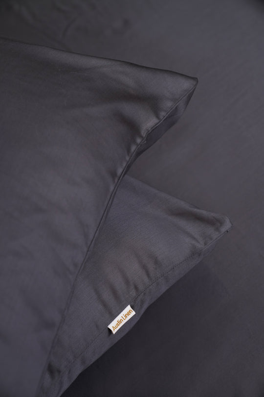 Dark gray bedding set with a visible brand label on a dark background