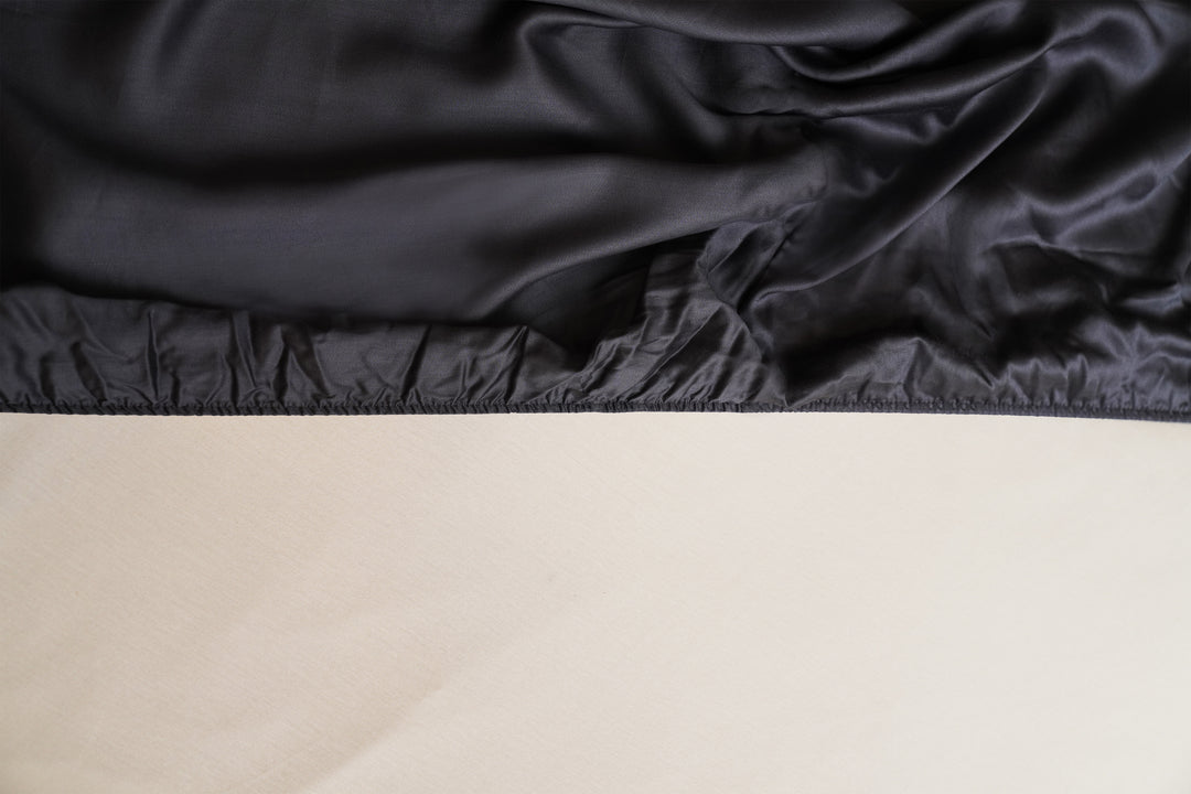 Close-up of black satin fabric draped over a beige surface