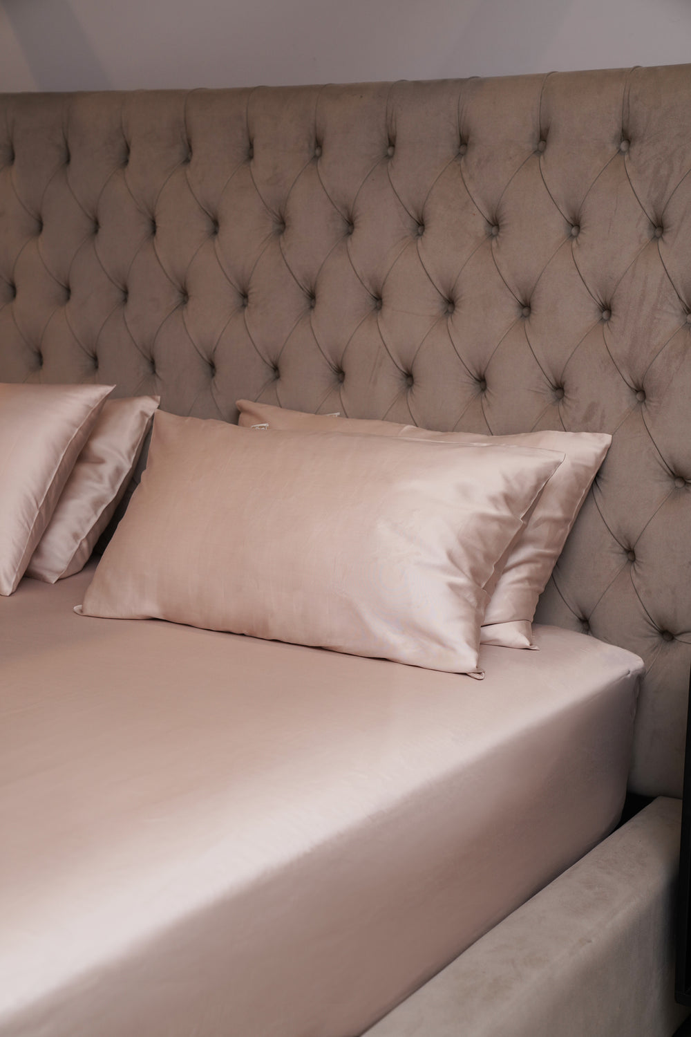 Beige bed with tufted headboard and pillows