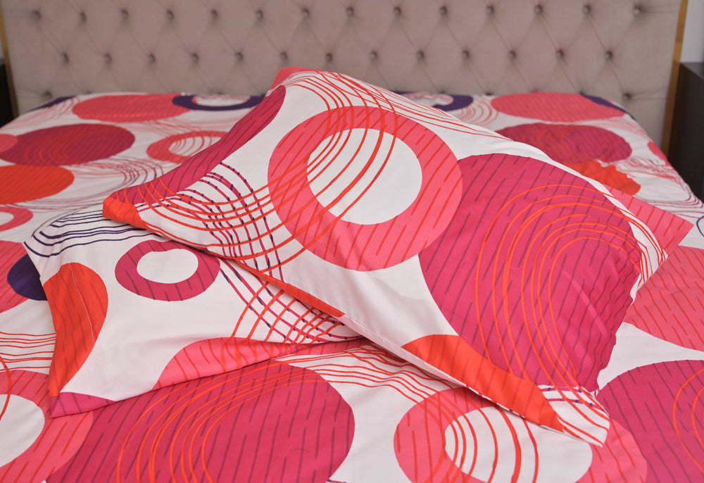 Colorful circular patterned bedspread on a bed with a tufted headboard.